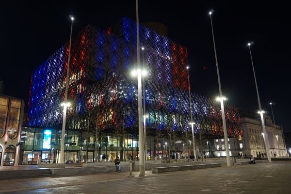 Library of Birmingham illuminated in red, white and blue.